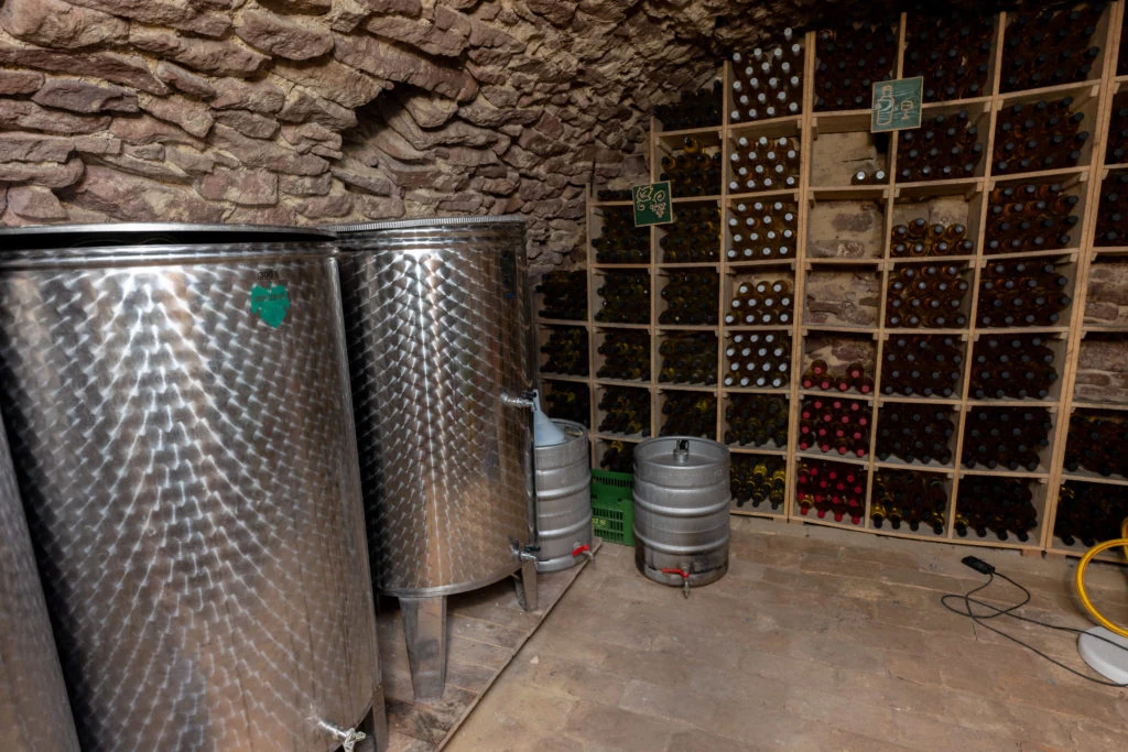 Weinlager im historischen Keller der Tabódy Villa mit Flaschenregalen und Edelstahltanks